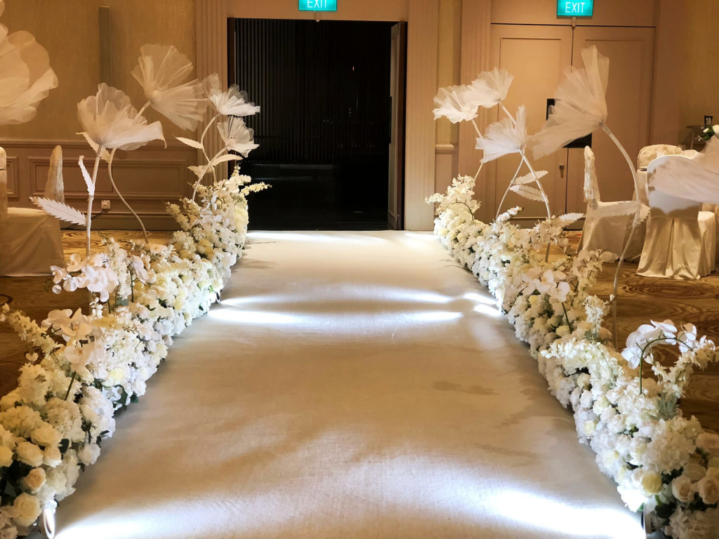 Full-length flower hedges lining an elegant wedding aisle styled by Zeaflora