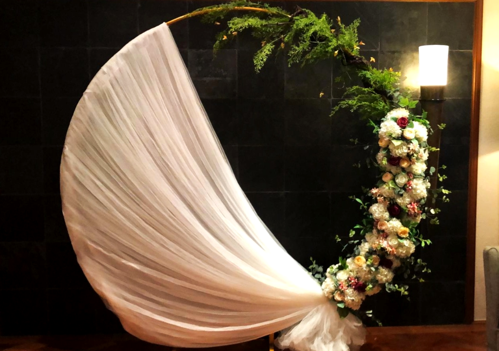 Classic solemnisation floral arch with white draping by Zeaflora