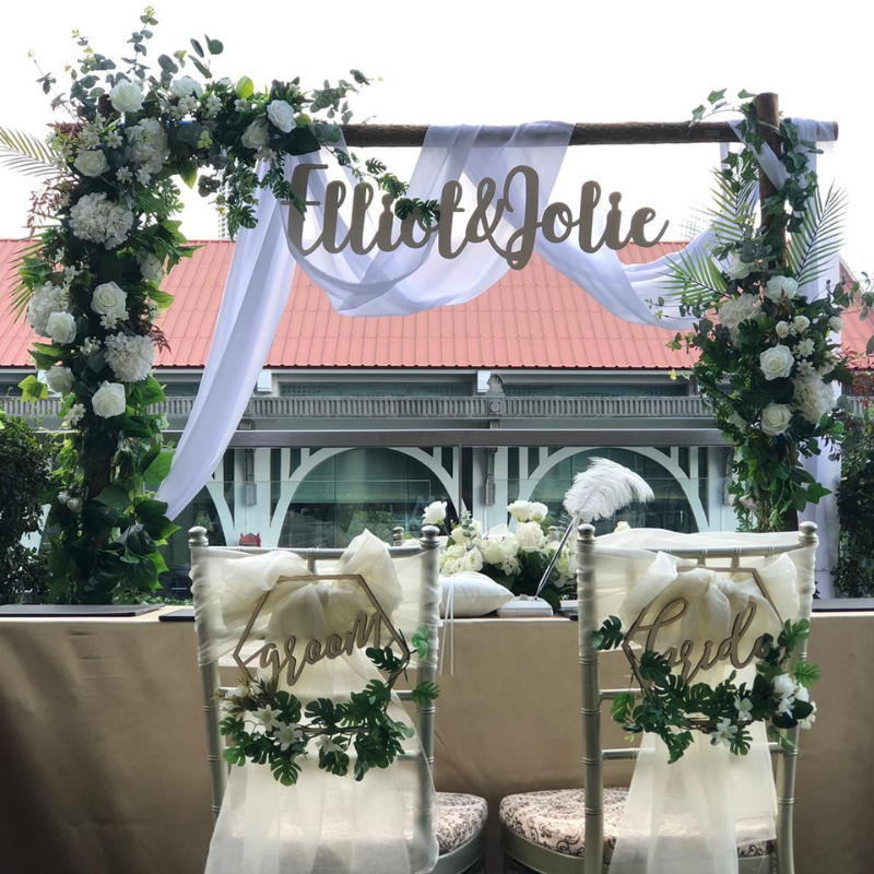 Premium solemnisation setup with floral arch bride and groom signage by Zeaflora