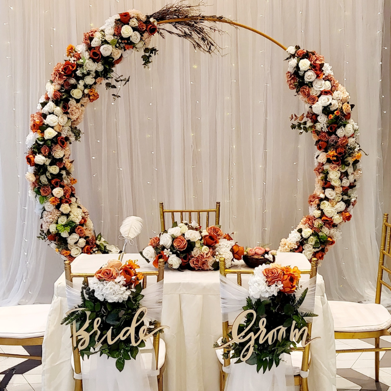 Premier solemnisation setup with floral arch white draping and Tiffany chairs by Zeaflora